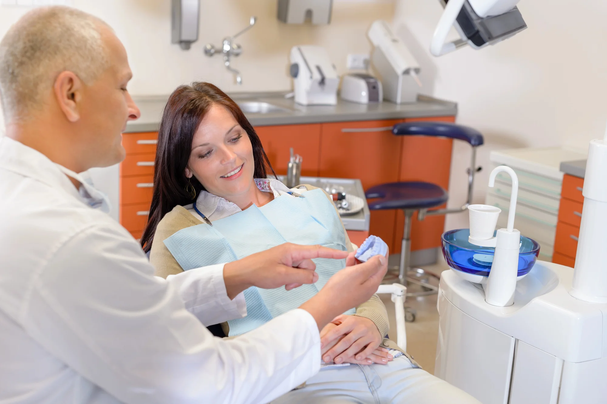 dentist explaining wisdom teeth removal Concord NC to female patient