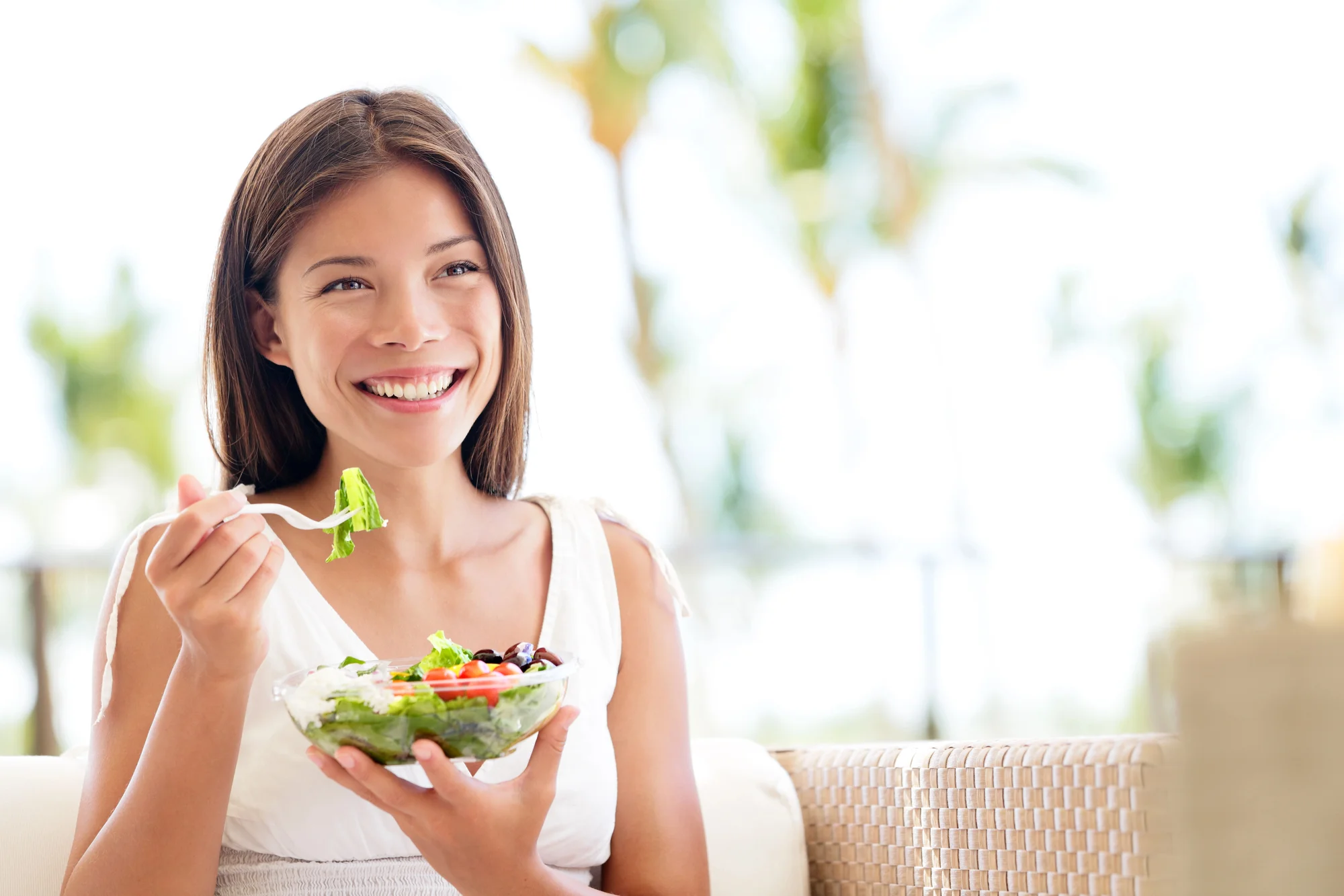 happy woman eating salad after wisdom teeth removal Concord NC