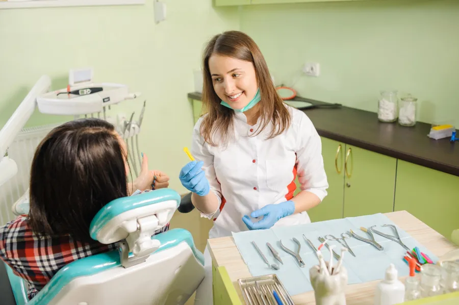 dentist showing a dental instrument to a patient in a dental clinic before wisdom tooth removal gastonia nc