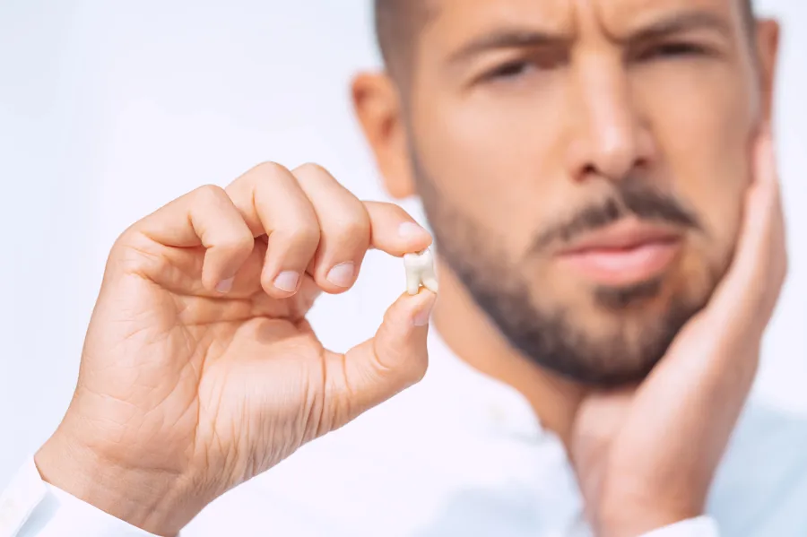 man holding wisdom tooth extraction pain