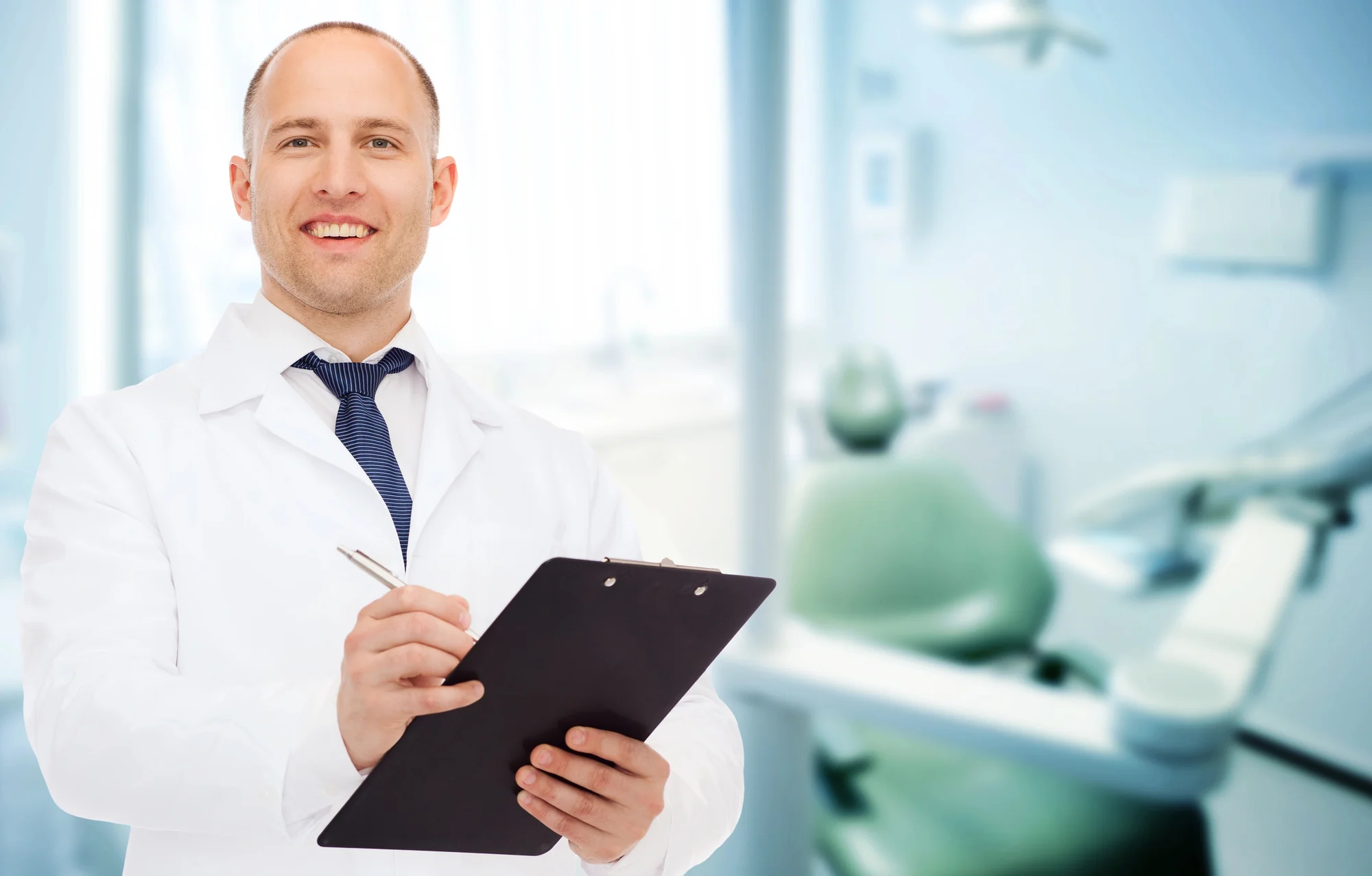 dentist-gastonia-nc-consultation-with-dentist-holding-clipboard-in-dental-office
