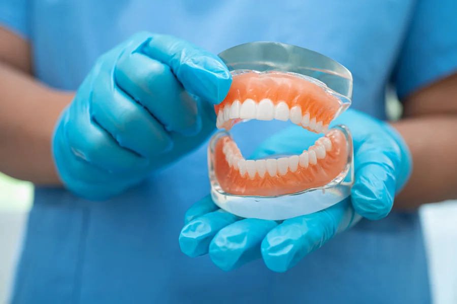 affordable dentures huntersville nc worker holding denture model