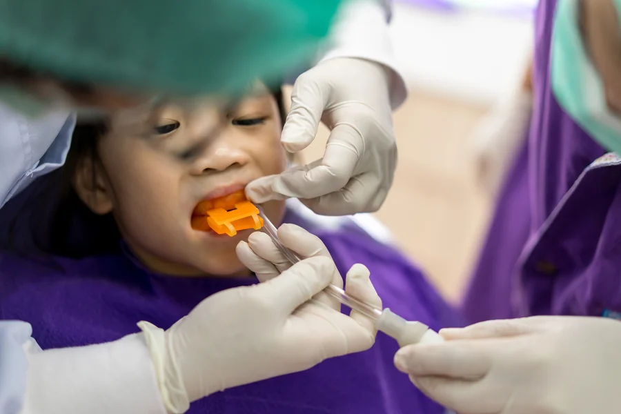 fluoride treatment gastonia child biting orange fluoride tray