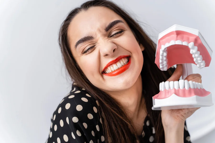 dental bridges hickory nc smiling woman holding large teeth model