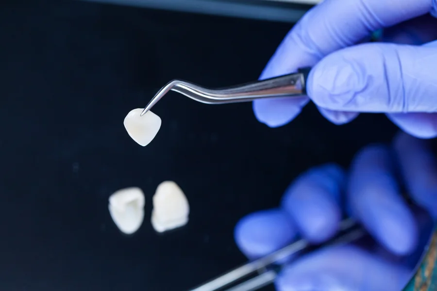 dental crowns harrisburg nc dentist holding porcelain crown with tweezers