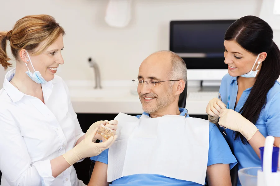 dentures in concord nc dentist showing patient a tooth model