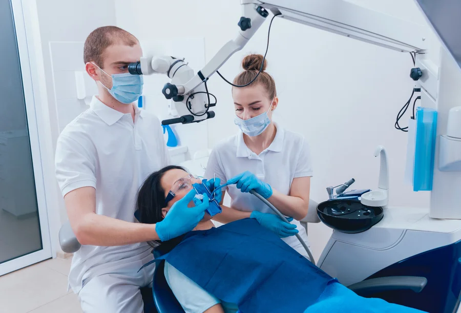 tooth extraction huntersville nc dentist and assistant using a microscope on a patient